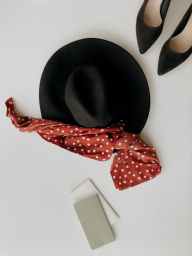 black hat beside pair of black pointed toe pumps