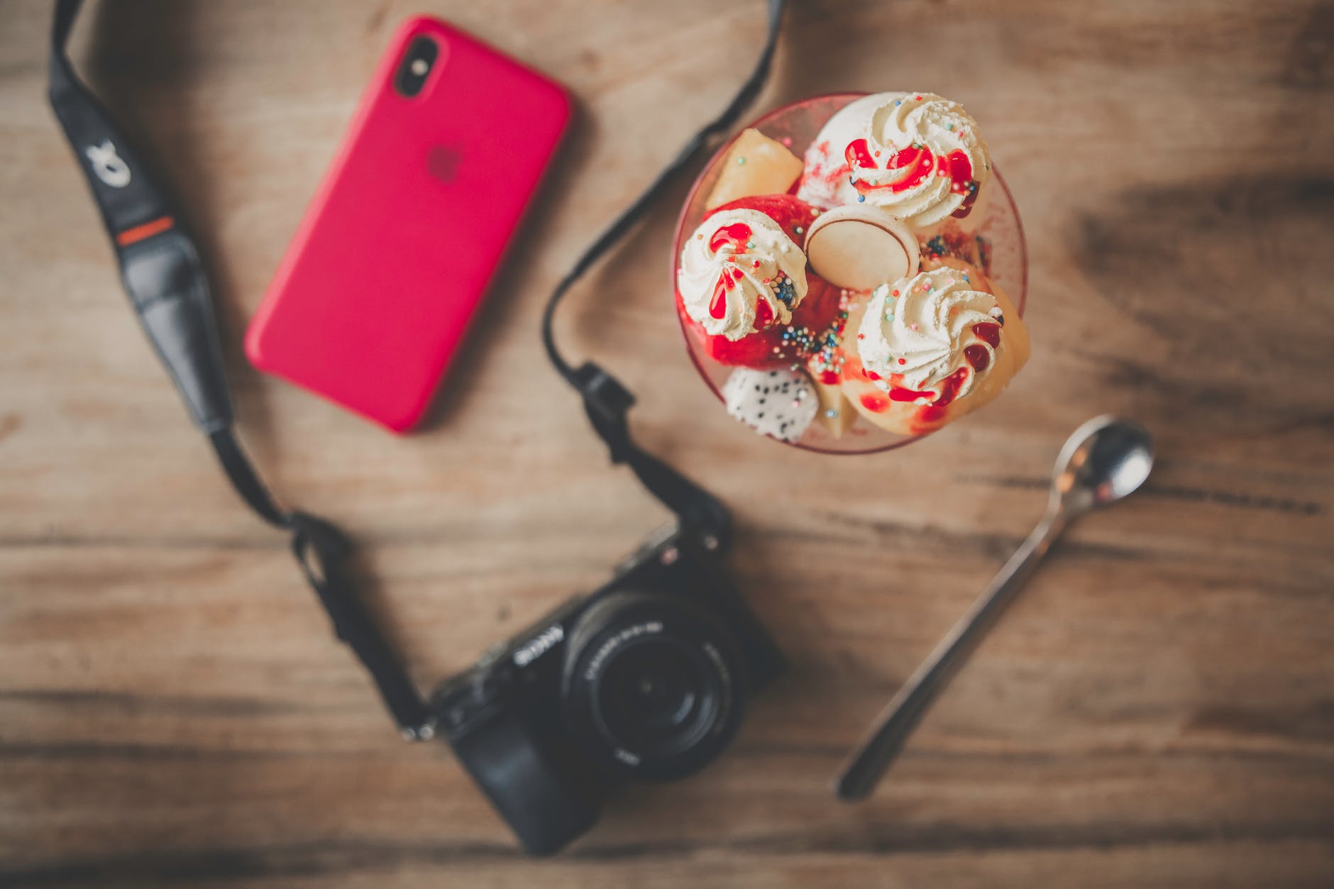 black dslr camera teaspoon ice cream and iphone x