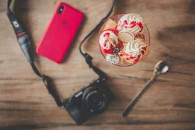 black dslr camera teaspoon ice cream and iphone x